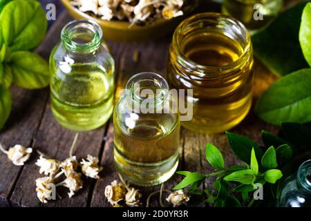 Ätherisches Öl in Glasflasche mit getrockneten Kamillenblüten, Schönheitsbehandlung. Spa-Konzept. Selektiver Fokus. Stockfoto