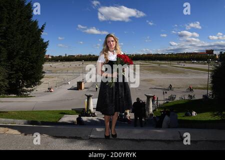 München, Deutschland. Oktober 2020. Das Münchner Kind Viktoria Ostler steht in einem schwarzen Gedenkdirndl für die abgesagte Wiesn 2020 mit einem Strauß roter Rosen auf den Stufen vor dem Bayern an der Theresienwiese. Quelle: Felix Hörhager/dpa/Alamy Live News Stockfoto