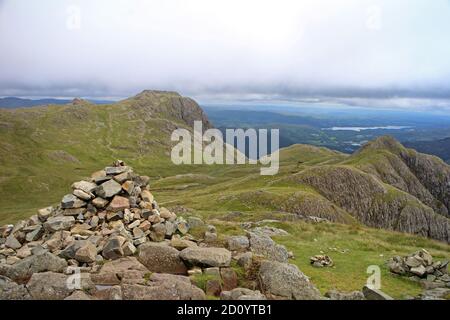 Blick auf Harrison Stickle und Dorn Crag von Pike of Stickle mit Leuten, die auf Harrison Coombe laufen Stockfoto