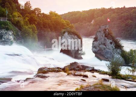 Größte Wasserfälle in Europa bei Sonnenuntergang. Rheinfall. Felsen über dem Fluss mit wunderschönen riesigen Wasserfall. Sprühen von Wasser, Dunst in der Luft über dem riv Stockfoto