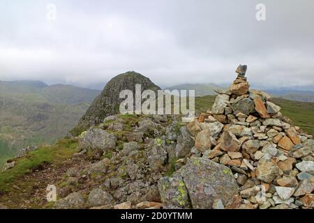 Blick auf Pike of Stickle von Loft-Klippe mit Spaziergängern auf dem Gipfel, Langdale Pikes Seengebiet Stockfoto