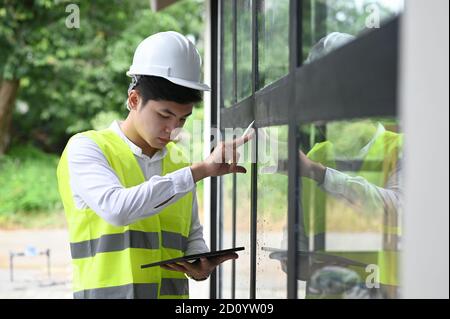 Gebäudeinspektor mit Tablette auf dem neuen Grundstück prüfen. Stockfoto