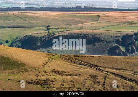 Fernansicht von Cow Low und Winnats Pass in Castleton vom Kinder Scout. Der Schaft der Longcliffe Mine ist nur in der Mitte des Abhangs sichtbar. Stockfoto