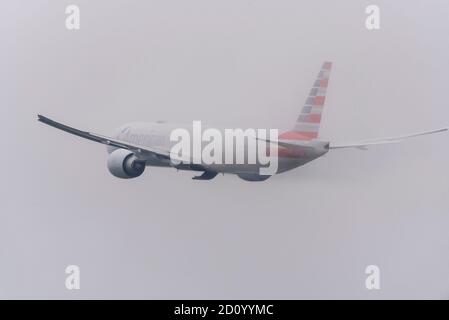 American Airlines Boeing 777 -300 Jet-Flugzeug N725AN Start bei schlechtem Wetter vom Flughafen London Heathrow, Großbritannien. Verschwinden in der Cloud Stockfoto