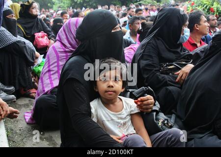 Dhaka, Bangladesch. Oktober 2020. Eine Wanderarbeiterin sitzt mit ihrem Kind vor dem Büro der Saudi Arabian Airlines im Pan Pacific Sonargaon Hotel in Dhaka, als sie wartet, um ihre Rückflugtickets zu ihrem Arbeitsziel in Saudi-Arabien abzuholen.bangladeschische Arbeiter, die nach Saudi-Arabien zurückkehren wollten, um zurückzukommen Um ihre Arbeit musste stundenlang warten, bevor sie ihren Flug zu erreichen, da der Flughafen nur eine kleine Menge von Menschen benötigt, um in, um die Coronavirus-Pandemie zu bekämpfen. Kredit: SOPA Images Limited/Alamy Live Nachrichten Stockfoto