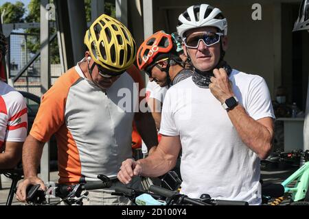 Beirut, Libanon. Oktober 2020. Der ehemalige US-Radfahrer Lance Armstrong (L) passt seine Gesichtsmaske am Eingang des Beiruter Hafens an, bevor er mit libanesischen und ausländischen Radfahrern an einem Radrennen teilnimmt, um Gelder zu sammeln und die libanesischen NGOs beim Wiederaufbau Beiruts nach der massiven Hafenexplosion in Beirut zu unterstützen. Quelle: Marwan Naamani/dpa/Alamy Live News Stockfoto