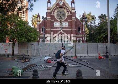 Santiago, Chile. Oktober 2020. Ein Protestler kommt während des Protestes an zerstörten Einrichtungen vorbei.Hunderte Demonstranten konfrontieren die Polizei in der Nähe der Plaza Baquedano, die von den Menschen in "Plaza de la Dignidad" umbenannt wurde, um Gerechtigkeit für Antoni zu fordern, einen 16-Jährigen, der am vergangenen Protesttag von der Polizei von einer Brücke geworfen wurde. Kredit: SOPA Images Limited/Alamy Live Nachrichten Stockfoto