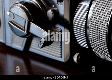 Nahaufnahme, Großformatkamera (Fokus auf Filmpasskurbel), auf braunem Tisch Stockfoto