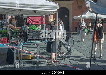 Bologna: Menschen mit OP-Maske warten auf dem Obst- und Gemüsemarkt im Freien zu kaufen (Covid-19 2020 Pandemie) Stockfoto