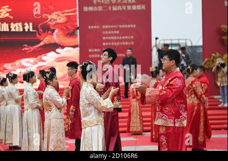 Dezhou, Dezhou, China. Okt. 2020. ShandongÃ¯Â¼Å'CHINA-am 29. September nahmen 29 Paare im chinesischen Stil an der 20. Jugendkollektivhochzeit Teil, die vom Jugendverband Dezhou und dem städtischen Parteikomitee der Kommunistischen Jugendliga Dezhou im Changhe Park abgehalten wurde. Die Hochzeit ist in neue Aufnahme, Gelübde von Brautpaar, Eintracht mit dem Rand, Rand dieses Leben, viel Freude und andere Verbindungen, zur klassischen Musik, Löwentanz und andere Formen der Feier, voll demonstriert den Charme der traditionellen chinesischen Kultur und Vitalität, Die Verschmelzung von reichen traditionellen chinesischen Kulturelementen. Stockfoto