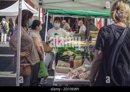 Bologna: Menschen mit OP-Maske warten auf dem Obst- und Gemüsemarkt im Freien zu kaufen (Covid-19 2020 Pandemie) Stockfoto