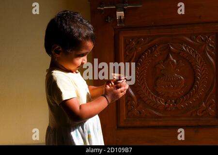 Kalaburagi, Karnataka/Indien-September 02.2020: Nahaufnahme eines indischen Mädchens, das Messingtopf in der Hand hält und morgens zur Lord Sun anbetet Stockfoto