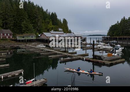 Blick auf Telegraph Cove an einem bewölkten Morgen mit Kajakfahrern im Untergrund. Stockfoto