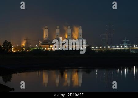 Industrielle Skyline-Landschaft des Connah's Quay Power Station, ein Kombikraftwerk, das nachts im River Dee nachstellt. Stockfoto