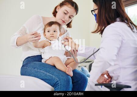 Kinderarzt hört auf Atem Stockfoto