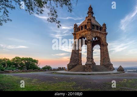 Das Kaiser-Wilhelm-Denkmal an der Porta Westfalica (Deutschland, Nordrhein-Westfalen) nahm am späten Nachmittag und einem blauen Himmel mit roten Linienwolken auf Stockfoto