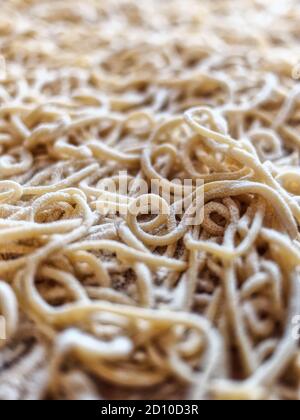 Nahaufnahme Italienische hausgemachte, ungekochte Pasta auf Holzbrett Blick von oben Stockfoto