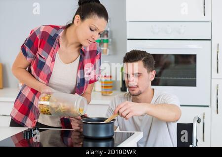 Behinderte im Rollstuhl zusammen - Mann paar kochen Stockfoto