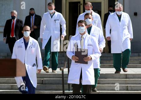 Bethesda, Maryland, USA. Oktober 2020. Commander Sean Conley (Front R), Arzt des Präsidenten, leitet ein Ärzteteam, um über den Zustand von US-Präsident Donald J. Trump im Walter Reed National Military Medical Center, wo Trump nach positiven Tests auf Covid behandelt wird, in Bethesda, Maryland, USA, zu informieren. 04. Oktober 2020.Quelle: Michael Reynolds/Pool via CNP Quelle: dpa/Alamy Live News Stockfoto