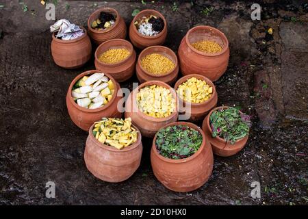 Buntes Gemüse, Obst, Blätter und Linsen vegetarisches Essen in braunen Tontöpfen in Bhubaneswar, Indien Stockfoto