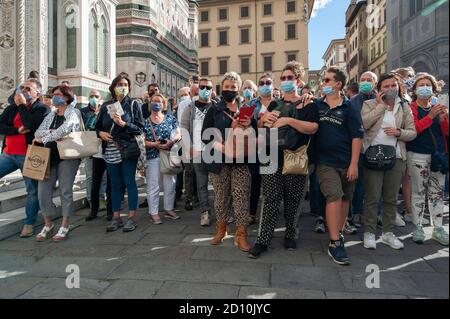 Florenz, Italien - 2020. September 26: Touristen (nicht identifizierte Personen) tragen Gesichtsmasken und fotografieren mit dem Telefon auf der Straße, während Coronavirus. Stockfoto