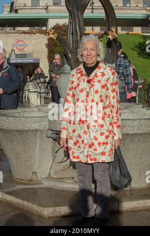 Senioren gesehen tragen einen Mantel mit Drucken von roten Mohnblumen in Erinnerung Sonntag 2018 in der Nähe des Eingangs der Green Park U-Bahn-Station. Stockfoto