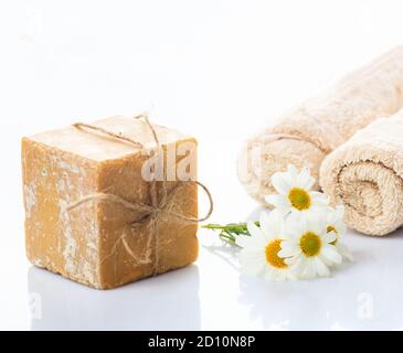 Hausgemachte Kamillenseife. Handgemachtes Seifenstück und frische Blumen auf weißem Hintergrund, Nahaufnahme. Natürliche gesunde Kräuterkosmetik Stockfoto