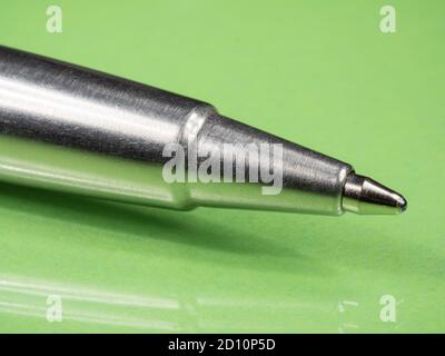 Metallstift mit einer Stange Nahaufnahme. Grüner Hintergrund. Makro . Stockfoto