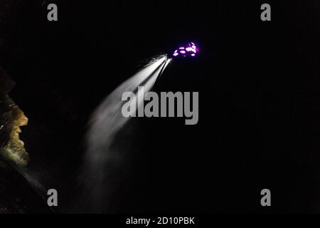 Flyboarding bei Nacht in einem Steinbruch in der Tschechischen Republik. Ein nicht identifizierter Mann führt nachts das Flyboarding durch. Bewegungseffekt, Langzeitbelichtung. Stockfoto