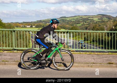 Männlicher Radfahrer, der grün Planet X EC-130E Rivet Rider SRAM Force 22 Aero Rennrad; Sport Rennrad auf Landstraße Überquerung Autobahnbrücke in ländlichen Lancashire, Großbritannien Stockfoto