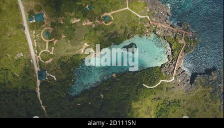 Top down von Limpid türkisfarbenen See mit entworfenen Wege auf grünem Tal in Luftaufnahme. Niemand Asien Natur Landschaft von Weekuri Lagune, Sumba Insel, Indonesien, Asien. Tolle Sommerlandschaft Stockfoto