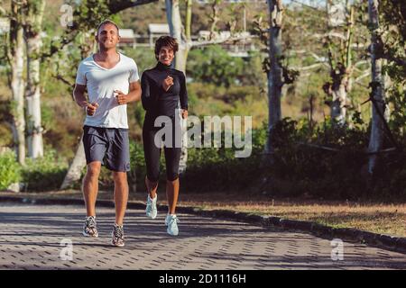 Ein Kerl mit einem Mädchen, das im Park ein Warm-up macht. Hochwertige Fotos Stockfoto