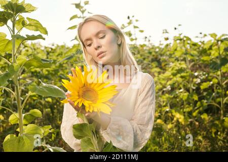 Schöne junge blonde Frau im Landhausstil Kleid stehen in Vorderseite der Kamera Stockfoto