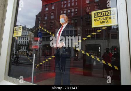 Die Menschen beobachten die Wachsfigur von US-Präsident Donald Trump Tragen Sie Gesichtsmaske im Fenster mit Zeichen Vorsicht Quarantäne Bereich im Madame Tussaud Museum A Stockfoto