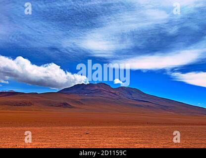 Anden Vulkangebirge in der Wüste. Wildnis Natur in Bolivien, Südamerika. Malerische Wolkenlandschaft im bolivianischen Himmel. Rotes, schlichtes Gelände. Stockfoto