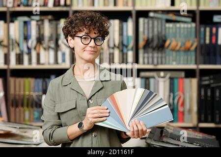 Serious junge Manager von Studio der Innenarchitektur zeigt Leder Beispiele Stockfoto