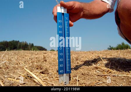 Thermometer im Boden im Sommer, Hitze und Trockenheit in der Landwirtschaft