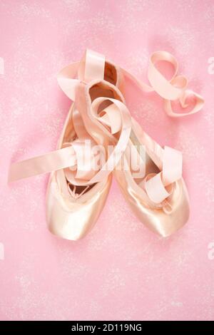 Pointe Ballet Schuhe ästhetische Thema Desktop-Arbeitsplatz Hintergrund auf stilvolle rosa texturierten Hintergrund. Top Ansicht Blog Held Header kreative Komposition f Stockfoto