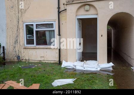 Aylesbury, Großbritannien. Oktober 2020. Sturm Alex Überschwemmungen in Aylesbury, Grafschaft Stadt Buckinghamshire. Ein Wochenende mit fast konstanten starken Regenfällen führte dazu, dass der Bear Brook seine Ufer überflutete Häuser in Southcourt Penn Road platzte. Als der fast ununterbrochene Regen nachlässt, beginnen die Bewohner den Schaden zu erreichen und beginnen aufzuräumen. Notdienste blockierten den Zugang zum überfluteten Bereich. Unwirksame Sandsäcke an der Eingangstür des überfluteten Grundstücks. Quelle: Stephen Bell/Alamy Stockfoto