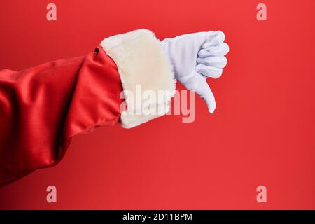 Hand eines Mannes trägt weihnachtsmann Kostüm und Handschuhe über rotem Hintergrund tut Daumen nach unten Ablehnung Geste, Ablehnung Abneigung und negatives Zeichen Stockfoto