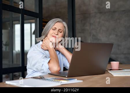 Müde gestresst älteren reifen Geschäftsfrau leiden unter Nackenschmerzen. Stockfoto