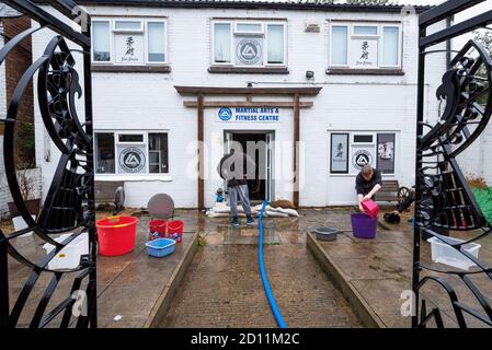 Aylesbury, Großbritannien. Oktober 2020. Sturm Alex Überschwemmungen in Aylesbury, Grafschaft Stadt Buckinghamshire. Ein Wochenende mit fast konstanten starken Regen veranlasste den Bear Brook, seine Ufer zu sprengen, bedrohte Häuser in Southcourt Kalifornien und überflutete das Martial Arts and Fitness Center. Als der fast ununterbrochene Regen nachließ, begann die Aufräumung des überfluteten Kampfsport- und Fitnesscenters mit Hilfe einer elektrischen Pumpe und Eimern. Quelle: Stephen Bell/Alamy Stockfoto