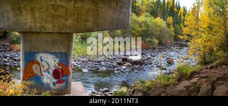 Panorama-Szene eines traurigen Clowns Gesicht gemalt auf einer Brücke Unterstützung entlang der Cascade River in Cook County, North Shore of Lake Superior, Minnesota Stockfoto