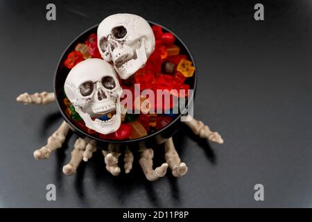 Skelett Kralle Hände mit Süßigkeiten und Hand Sanitizer - Halloween Konzept Stockfoto