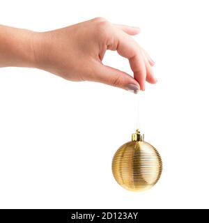 Weibliche Hand mit goldenem Weihnachtsball in der Hand Stockfoto