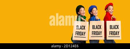 Drei Frauen Halten Einkaufstaschen Mit Black Friday Text, Studio Stockfoto