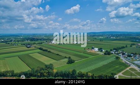 Luftaufnahme von Bauernhöfen im Sommer mit blauem Himmel Und weiße, flauschige Wolken Stockfoto