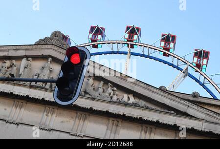 München, Deutschland. Oktober 2020. Ein beleuchtetes Riesenrad ist auf dem Königsplatz zusammen mit den Propyläen und einer roten Ampel zu sehen. Heute wäre das Ende des Oktoberfestes gewesen, das wegen des Coronavirus abgesagt wurde. Ebenso endete heute die Aktion 'Summer in der Stadt'. Quelle: Felix Hörhager/dpa/Alamy Live News Stockfoto