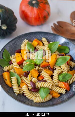 Vegane Herbstnudeln mit Kürbis und schwarzen Bohnen Stockfoto