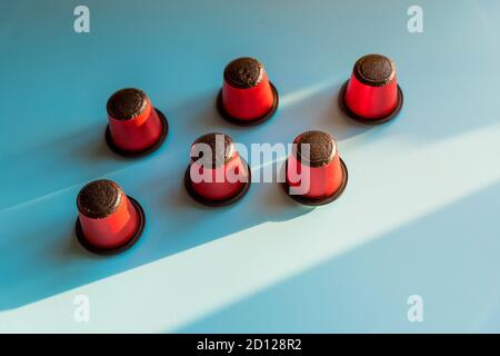 Italienische Espresso Kaffeekapseln oder Kaffeepads Zusammensetzung auf blauem Hintergrund, flach legen.Kaffee in Kapseln für Espresso Maschine. Kaffeeprodukte Stockfoto